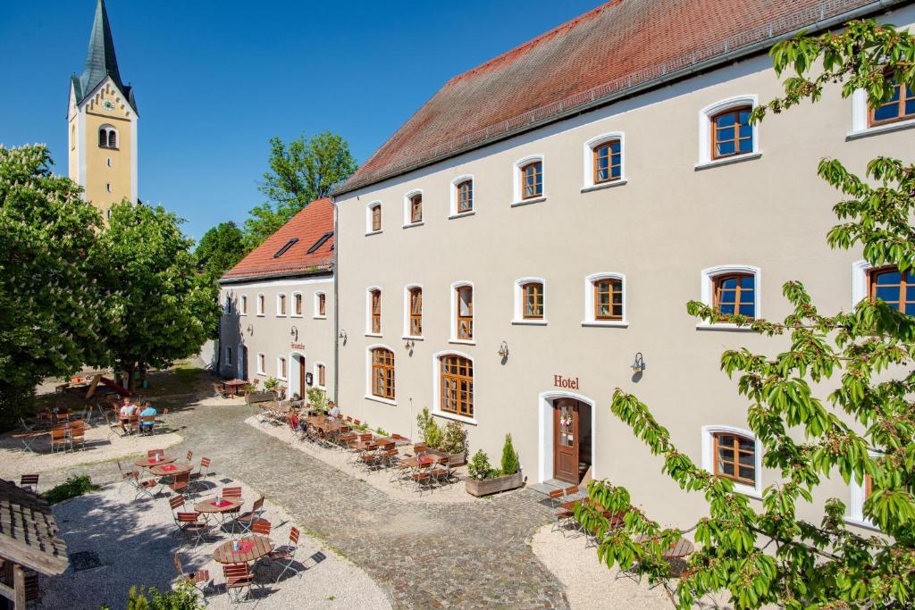an old building with a church in the background at Stanglbräu in Hausen