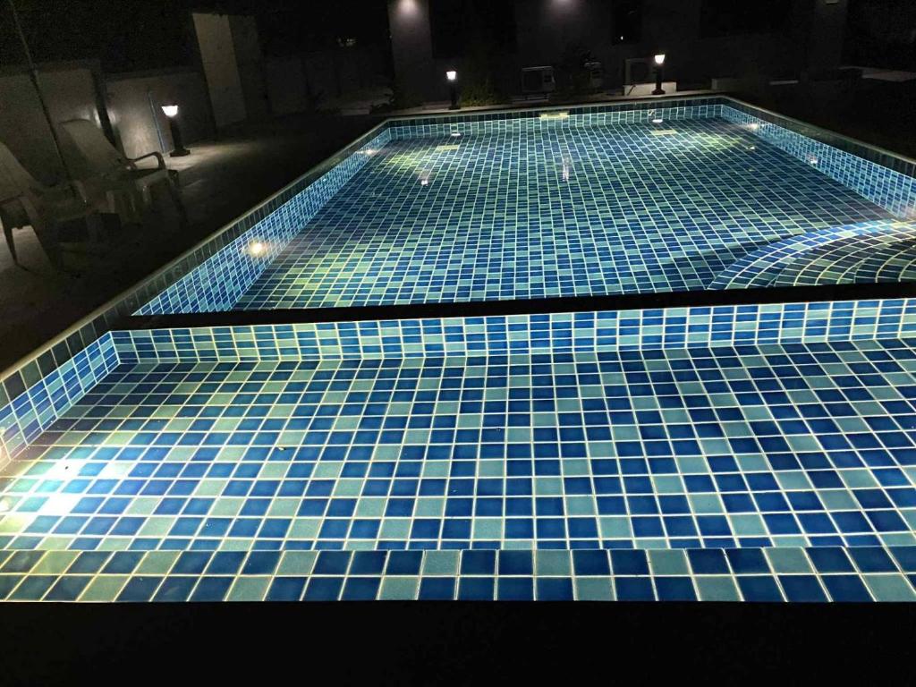 a swimming pool with blue tiles on it at Dan Mai Homestay in Trat