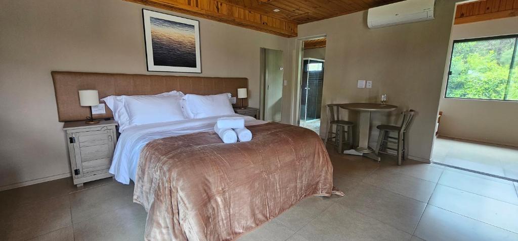 a bedroom with a bed with two towels on it at Pousada Trinca Ferro in Bom Retiro