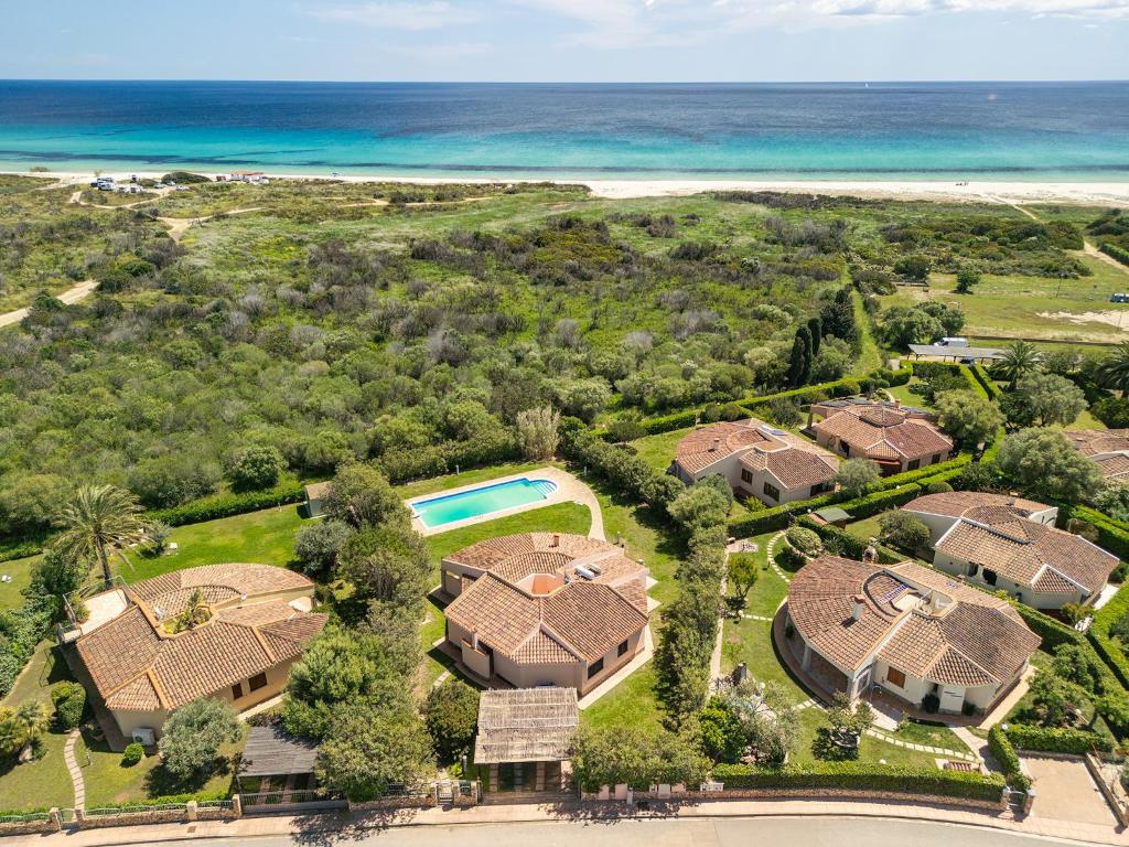 an aerial view of a house with a pool and the ocean at Villa Del Sole- in Costa Rei