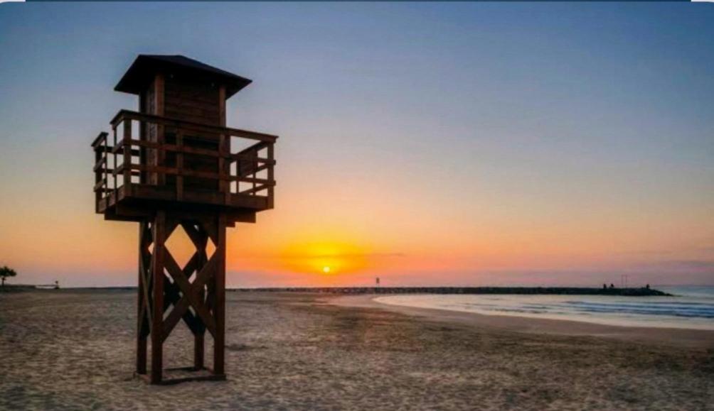 a lifeguard tower on the beach at sunset at Vistal Mar in Puerto de Sagunto