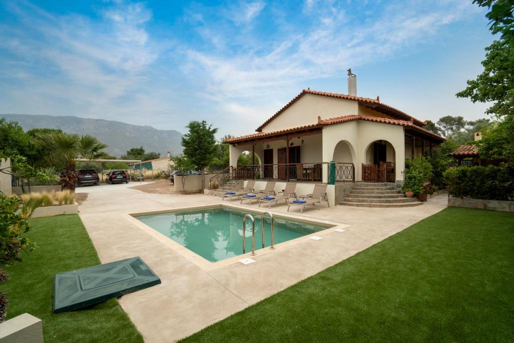 a house with a swimming pool in the yard at Villa Olivia in Loutraki