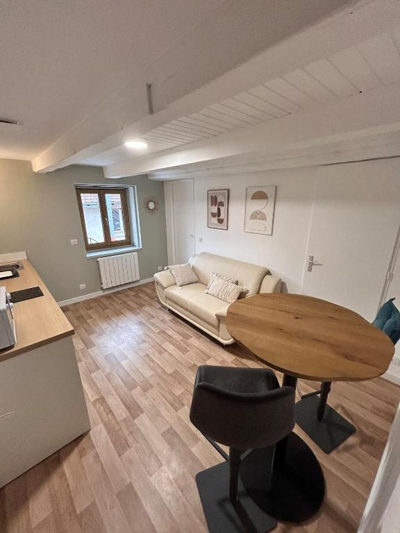a living room with a table and a couch at Le petit cocon in Pont-de-Veyle