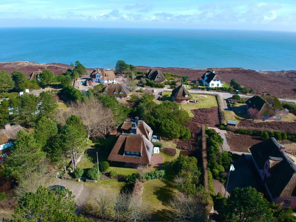 an aerial view of a house with the ocean in the background at Maltes Hüs in Braderup