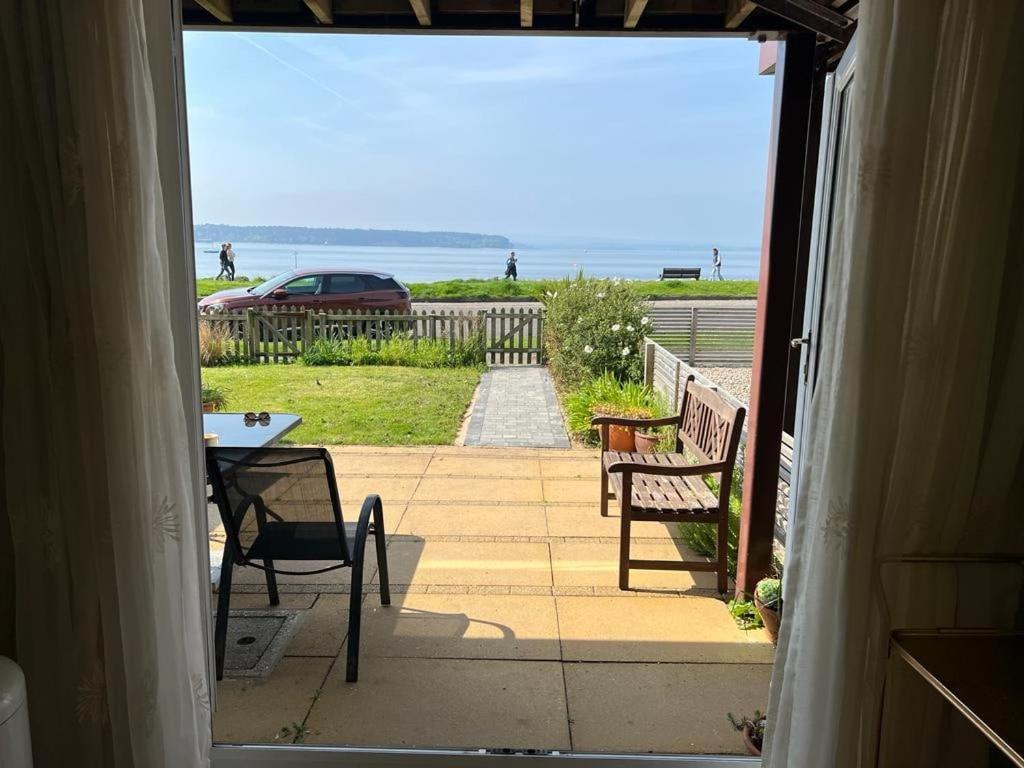 an open door to a patio with a table and chairs at Poole Harbour View in Poole