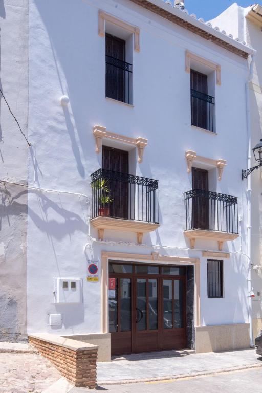 a white building with a wooden door and balcony at Casa Los Yayos in Segorbe