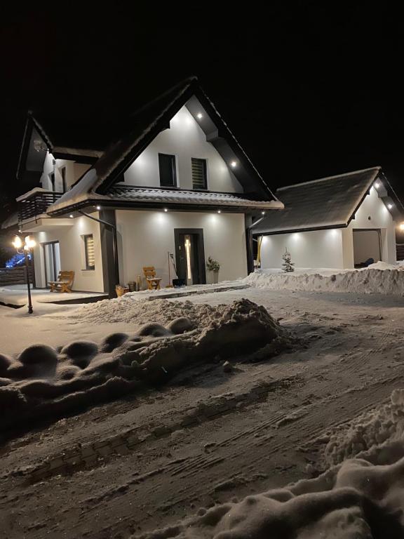 a house in the snow at night at Dom na Borówkowym Wzgórzu - Malo Stay in Paleśnica