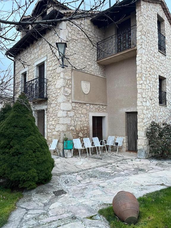 a large stone building with chairs and a balcony at Casa del Herrador I in Carrascal del Río
