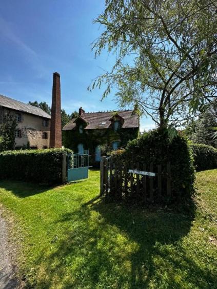 an old house with a gate in the yard at La Merlerie in Malicorne