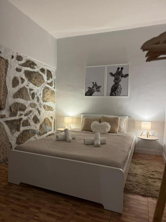 a bedroom with a large white bed with two lamps at Adoria GuestHouse in Adoria