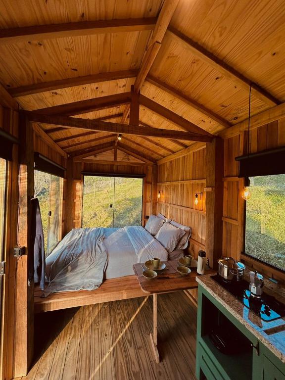 a bedroom with a bed in a wooden cabin at Romântica Cabana Serra do Vento Vista surreal in Passa Quatro