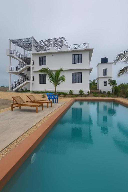 a building with a swimming pool in front of a building at Villa Katerina-Zanzibar Apartment Paje in Paje