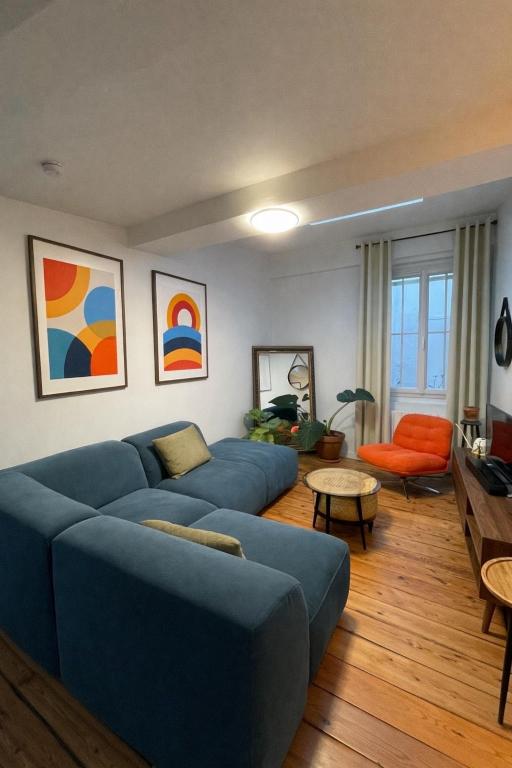 a living room with a blue couch and a table at L'Atelier Saint Michel in Bordeaux