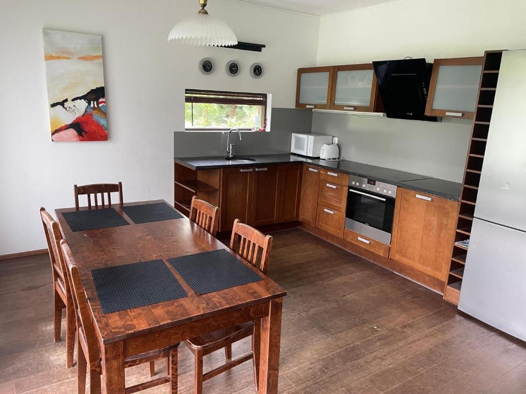 a kitchen with a wooden table and a dining room at Коттедж in Lappeenranta