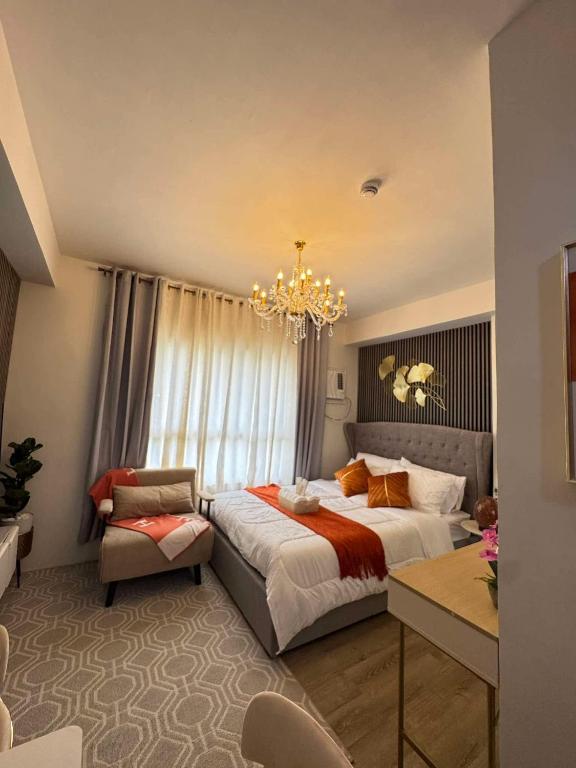 a bedroom with a large bed and a chandelier at Ona's Condo in Bacolod