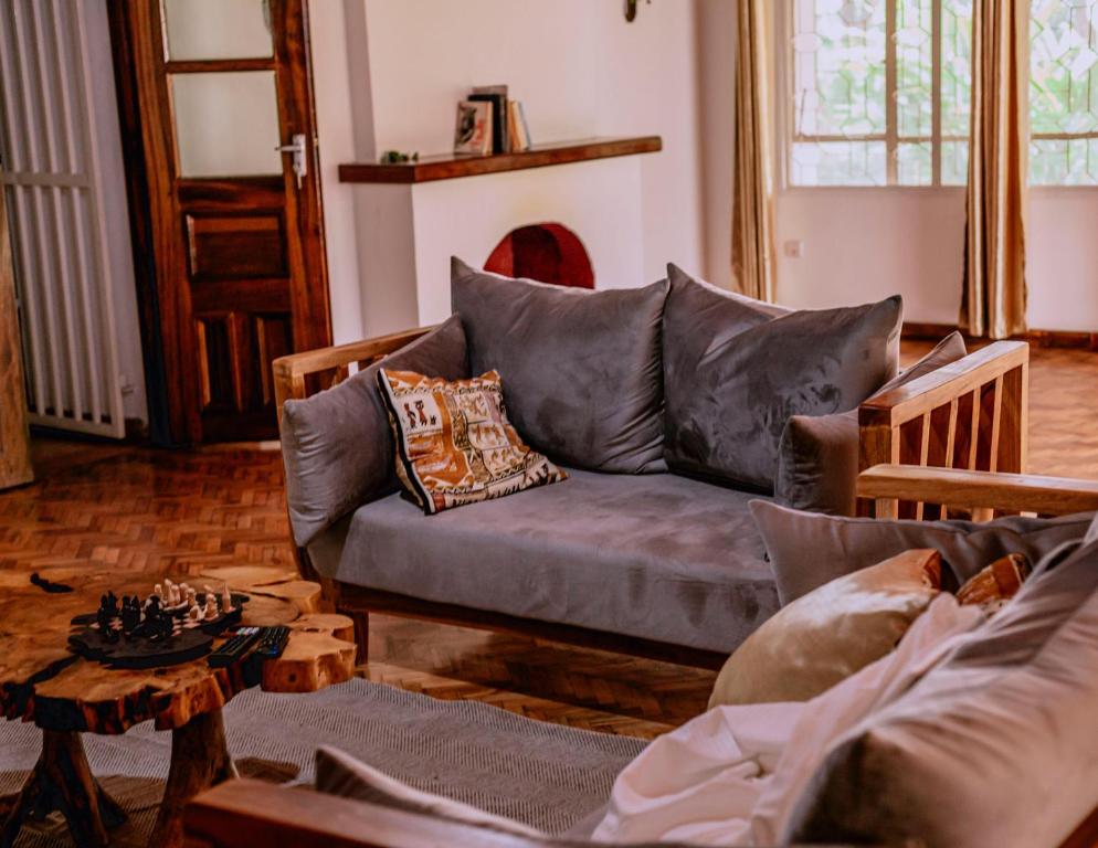 a living room with a couch and a table with a chess at Avana Home in Arusha