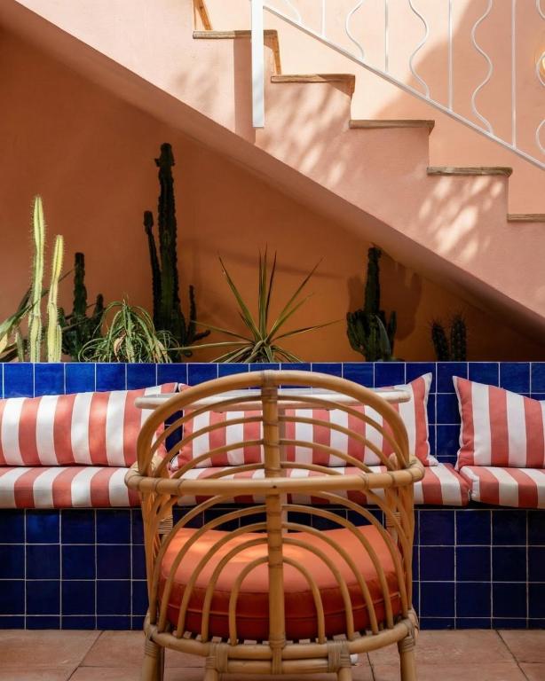 a rattan chair sitting in front of a bench at Hôtel Gabriel in Menton