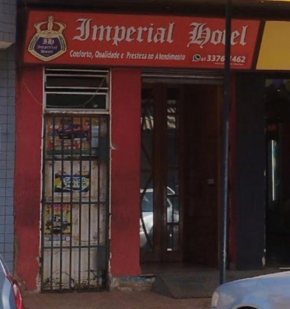 a red building with two doors and a sign on it at Imperial Hotel in Santo Antônio do Descoberto
