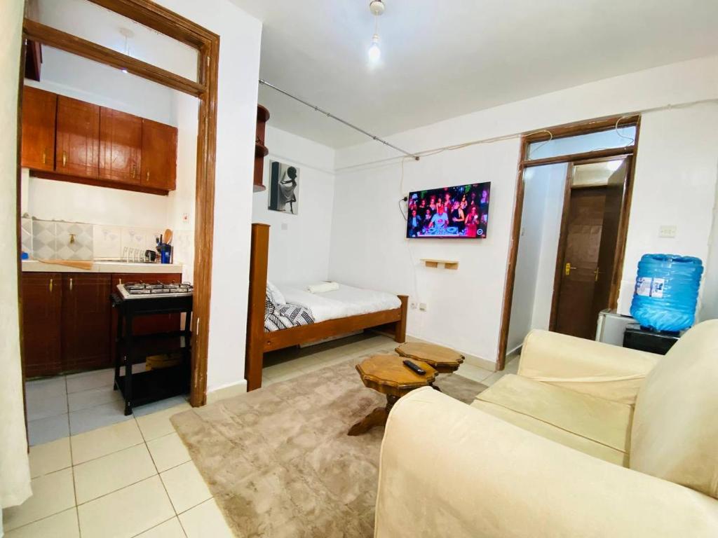 a living room with a couch and a bed at MJ Homes Eldoret Studio in Eldoret