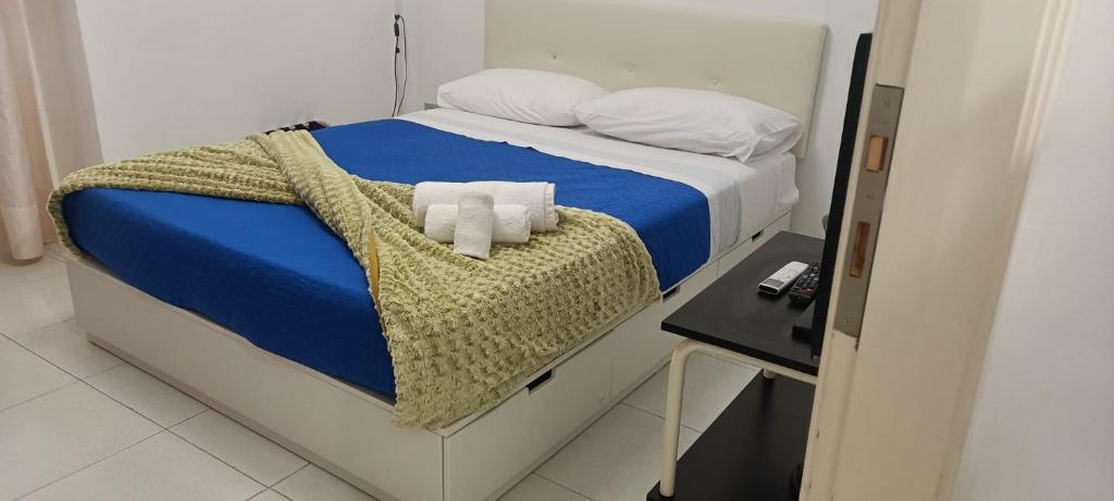 a bed with a blue blanket and two white pillows at Sun Terrace Sorrento in Sorrento