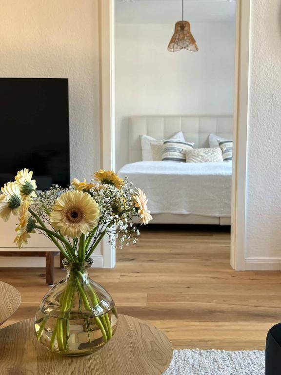 a vase with flowers on a table in a living room at Wanderlust East73 in Trier