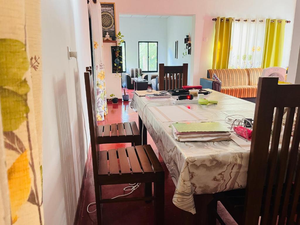 a room with a table and chairs and a living room at Liyos House in Matara