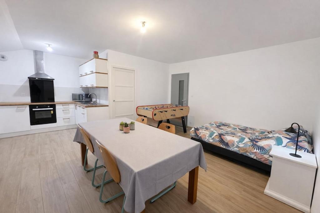 a room with a table and a bed and a kitchen at Grand studio équipé indépendant in Guipry-Messac