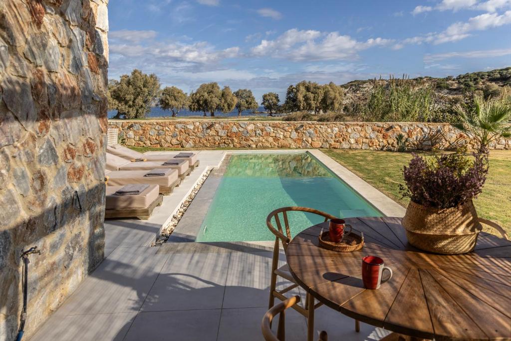 an outdoor patio with a table and a swimming pool at Norte Luxury Villas in Agioi Apostoli
