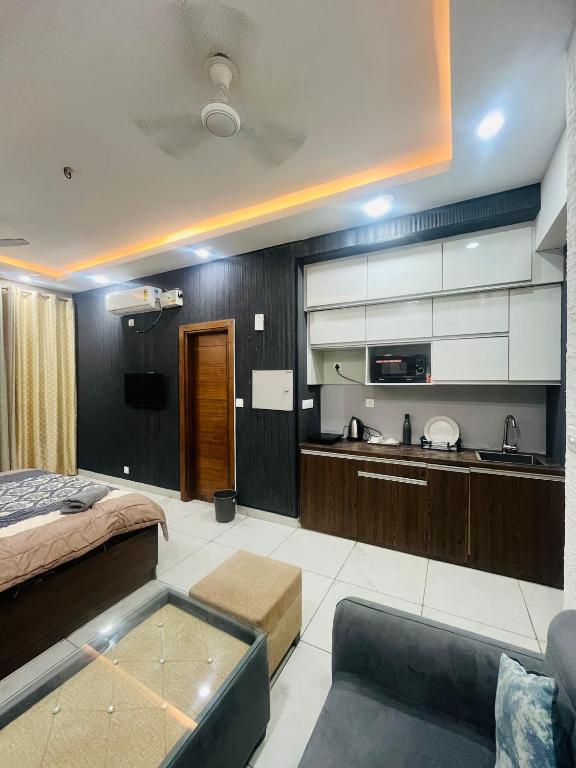 a room with a kitchen and a bed and a couch at cozy noida studio, super comfy!!!! in Noida