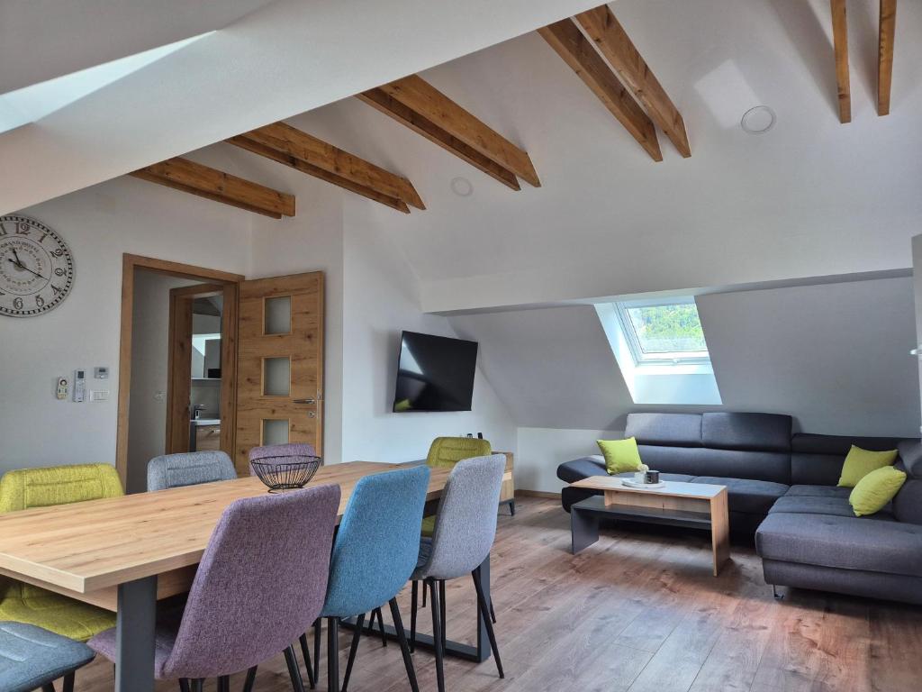 a living room with a wooden table and chairs at Vila Jelena - modern spacious apartments near Vintgar Gorge & Bled in Zgornje Gorje