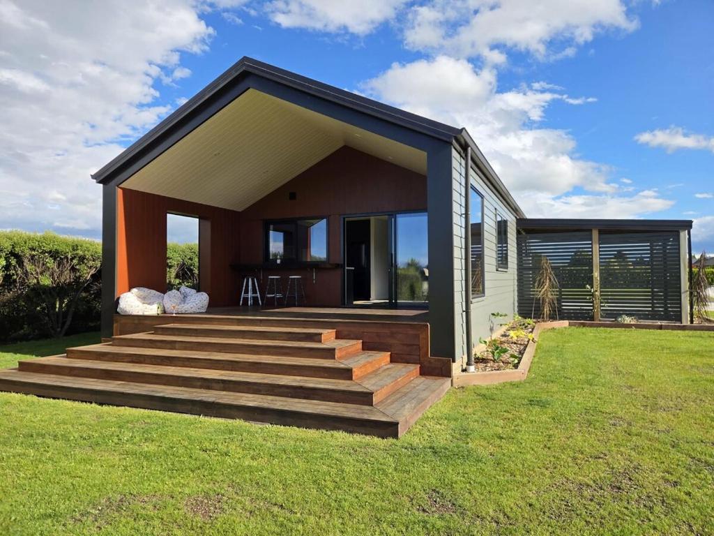 a small house with a porch and a deck at Pukutahi Palms in Te Anau