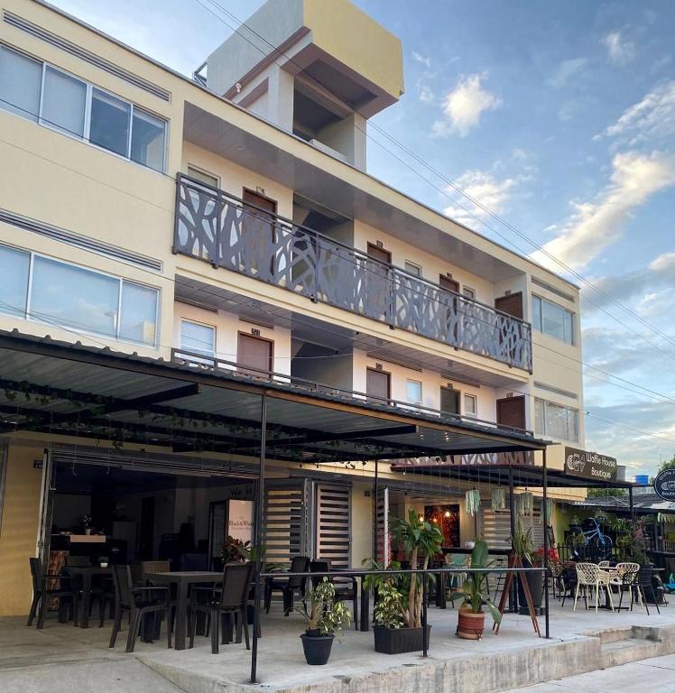 ein Gebäude mit einem Balkon mit Tischen und Stühlen in der Unterkunft Edificio Cardamomo in Neiva