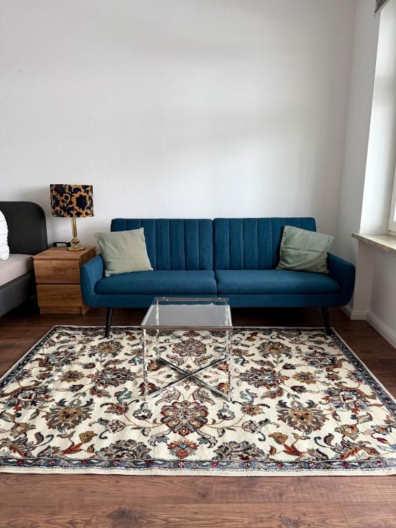a blue couch in a living room with a rug at Stilvolle Wohnung mit Rheinblick in Weißenthurm