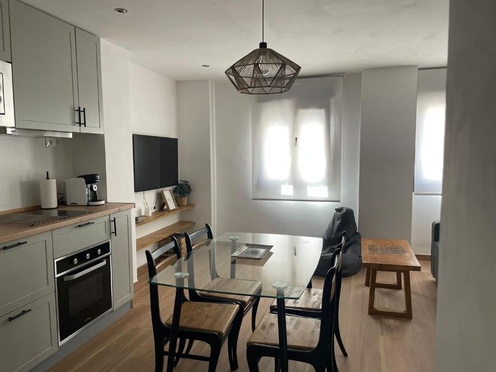 a kitchen with a glass table and chairs in a room at Entre Murallas in Doña Mencía