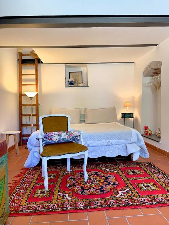 a bedroom with a bed and a chair and a rug at Casa Vacanze Pinuccia in Corniglia