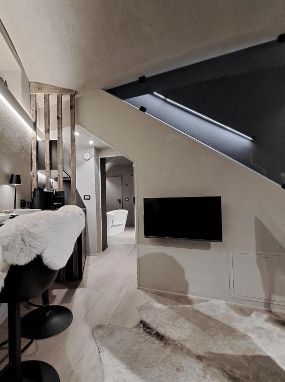 a living room with a tv on a wall at VHĀUS Apartment and Spa in Predazzo