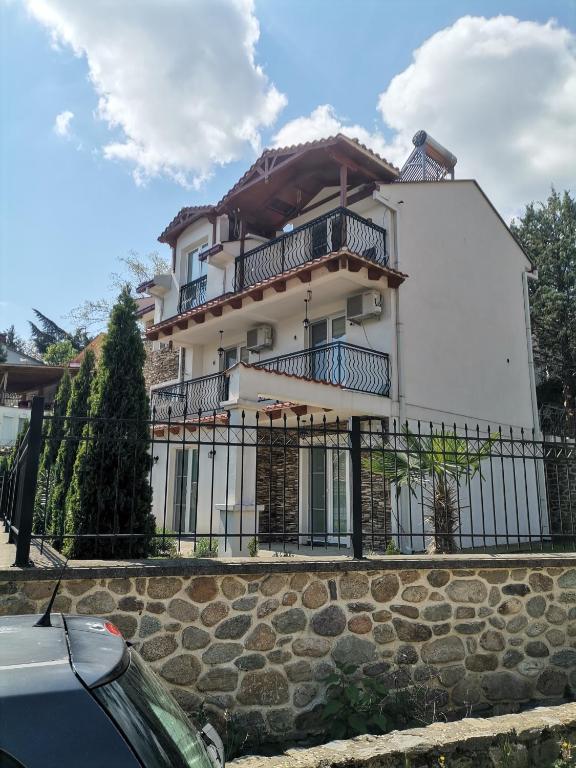 a white house with a fence in front of it at vila matejevic in Star Dojran