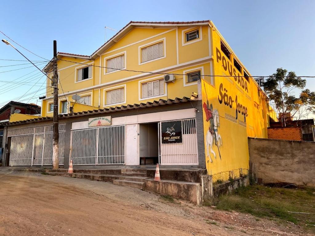 a yellow building on the side of a street at Casarão Hostel in Guaratinguetá