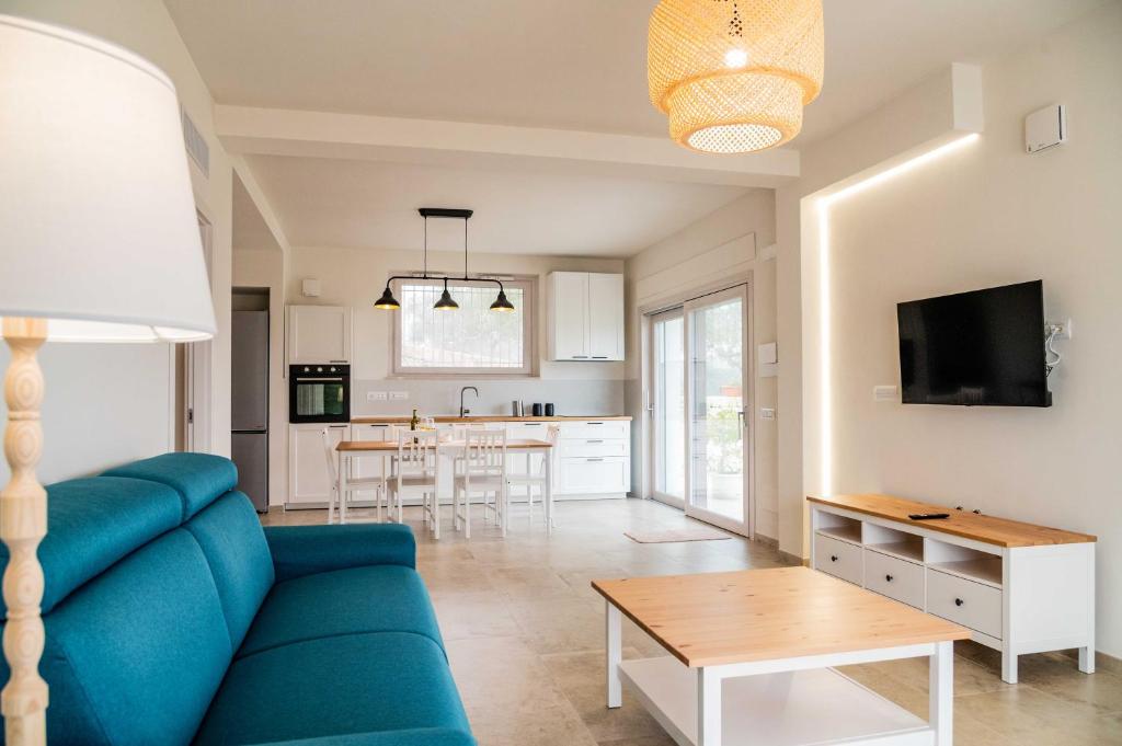 a living room with a blue couch and a table at Moderno Mediterraneo in Alberobello