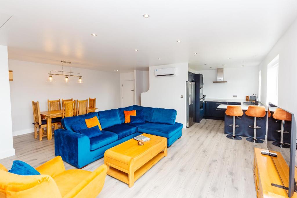 a living room with a blue couch and a table at Buzzards Retreat in Tiverton