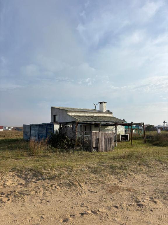 an old house sitting in the middle of a field at Rancho Tres11 in Cabo Polonio