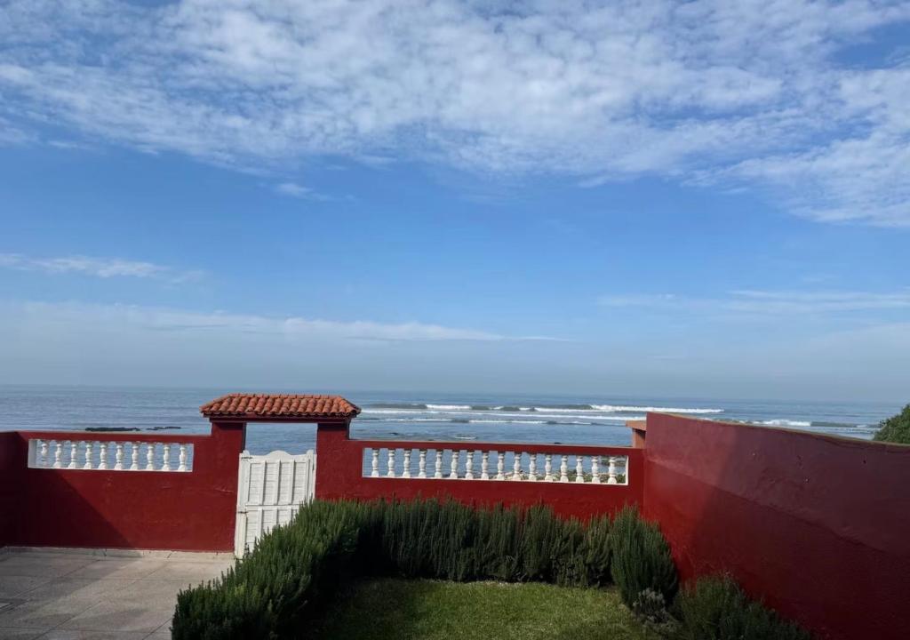 a red building with the ocean in the background at Maison front de mer in El Jadida