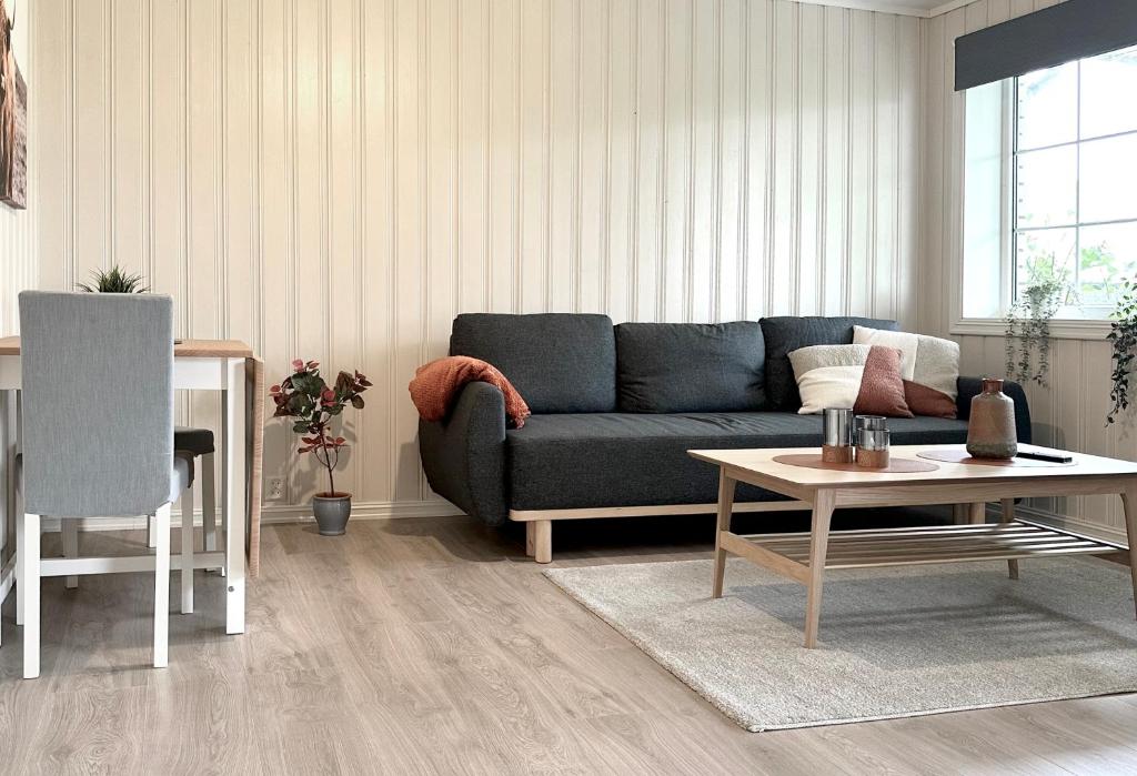 a living room with a blue couch and a table at Apartment centrally located in Bud in Bud