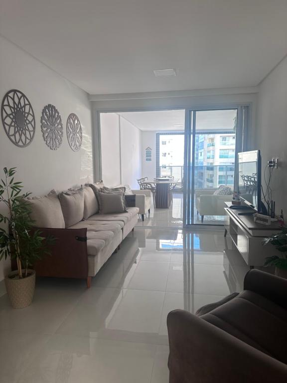 a living room with a couch and a piano at Apartamento 1001 in Guarapari