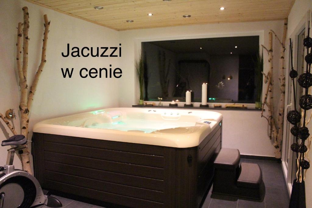 a jacuzzi tub in a bathroom with a sign at Kapi-Spa Pokoje i Apartamenty in Kluszkowce