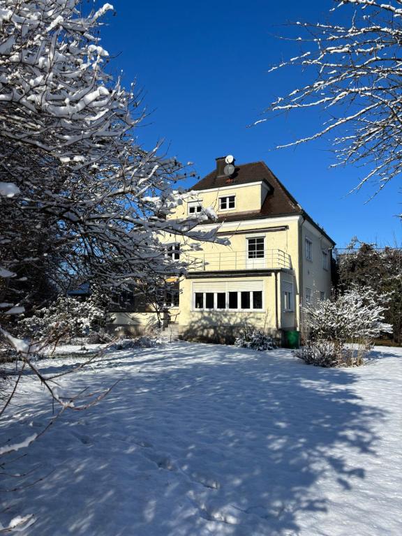 a large white house with snow on the ground at Villa Vilma Antica in Laufen