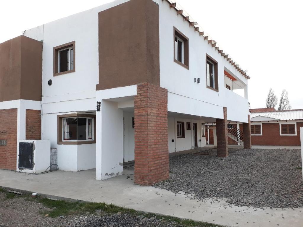 a large white building with a brick pillar at Tafi Apart in Sarmiento
