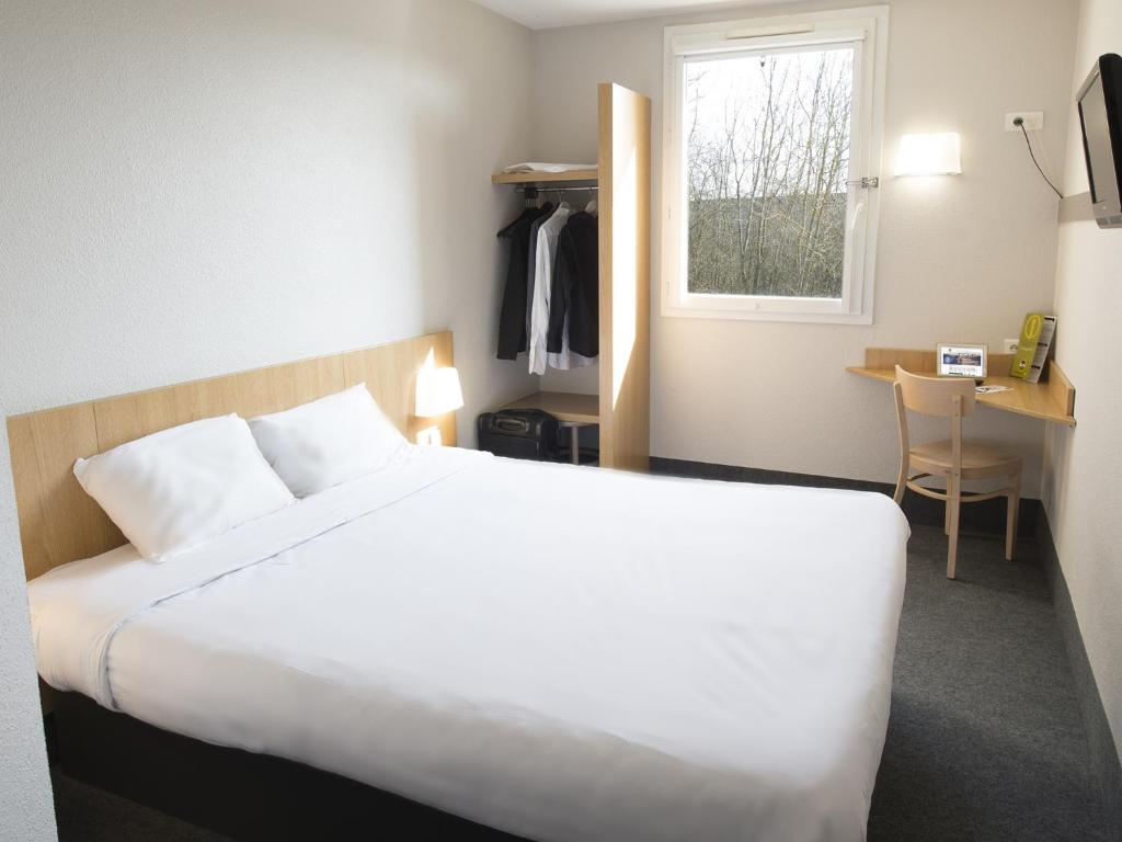 - une chambre avec un lit, un bureau et une fenêtre dans l'établissement B&B HOTEL Auxerre Monéteau, à Monéteau