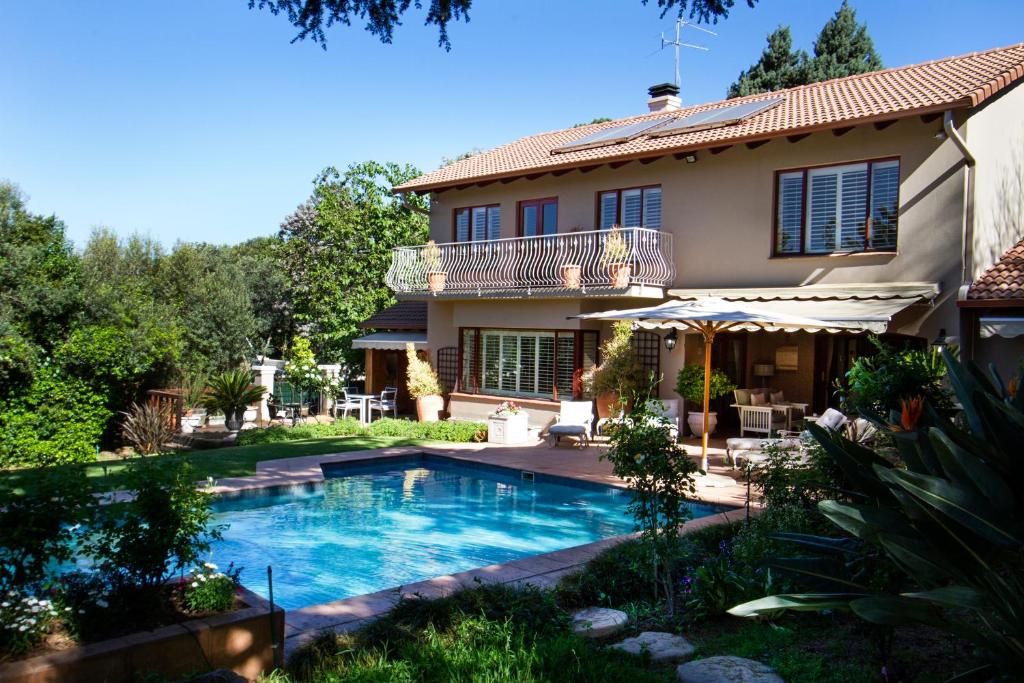 a house with a swimming pool in the yard at Bellgrove Guest House Sandton in Johannesburg
