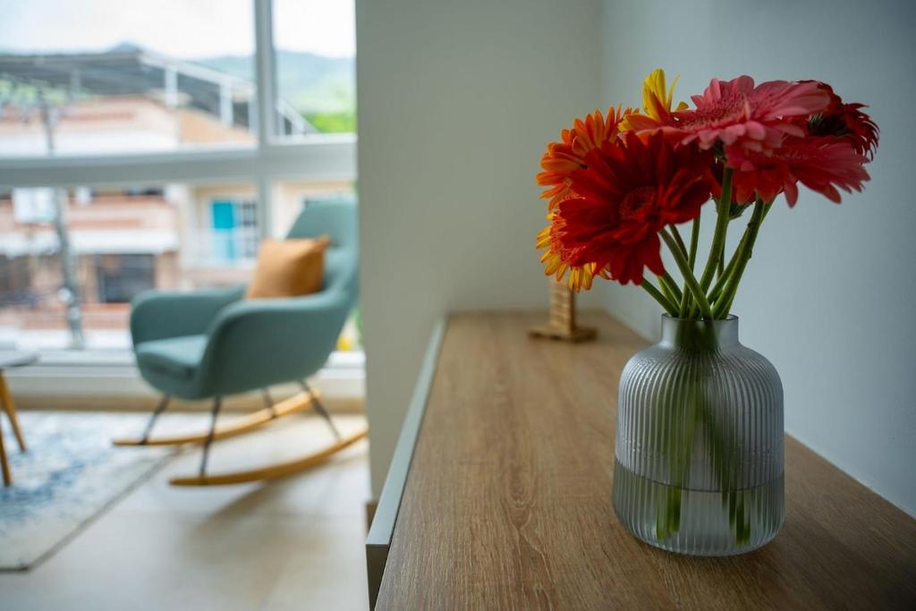 a vase filled with red flowers sitting on a table at Loft 202 North Cali - Montsari in Cali